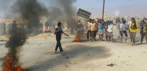 العشرات من إفراد المقاومة بلودر يقطعون الطريق الرئيسي ويحرقون إطارات السيارات للمطالبة بترقيمهم في اللواء 115