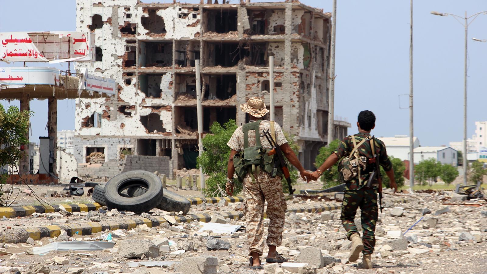 مقاتلان يمنيان في الشارع الرئيسي لإحدى المدن اليمنية الحدودية مع السعودية